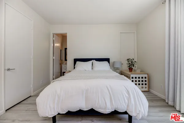 a bedroom with a bed and a potted plant