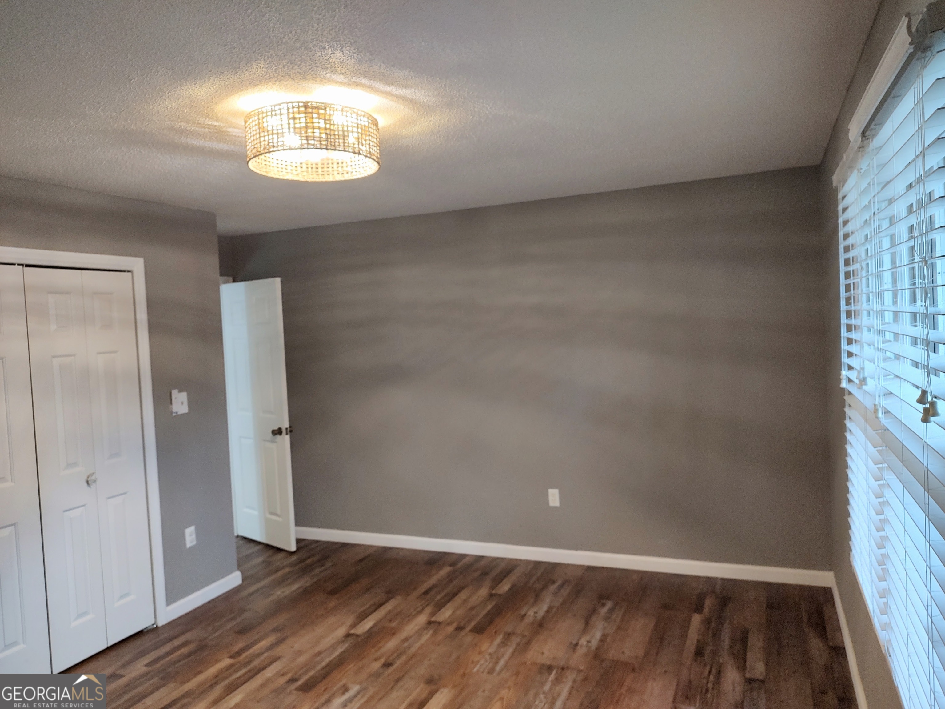 615 Hemlock Drive Thomson, GA 30824 - Photo 23 of 32 an empty room with wooden floor chandelier and windows