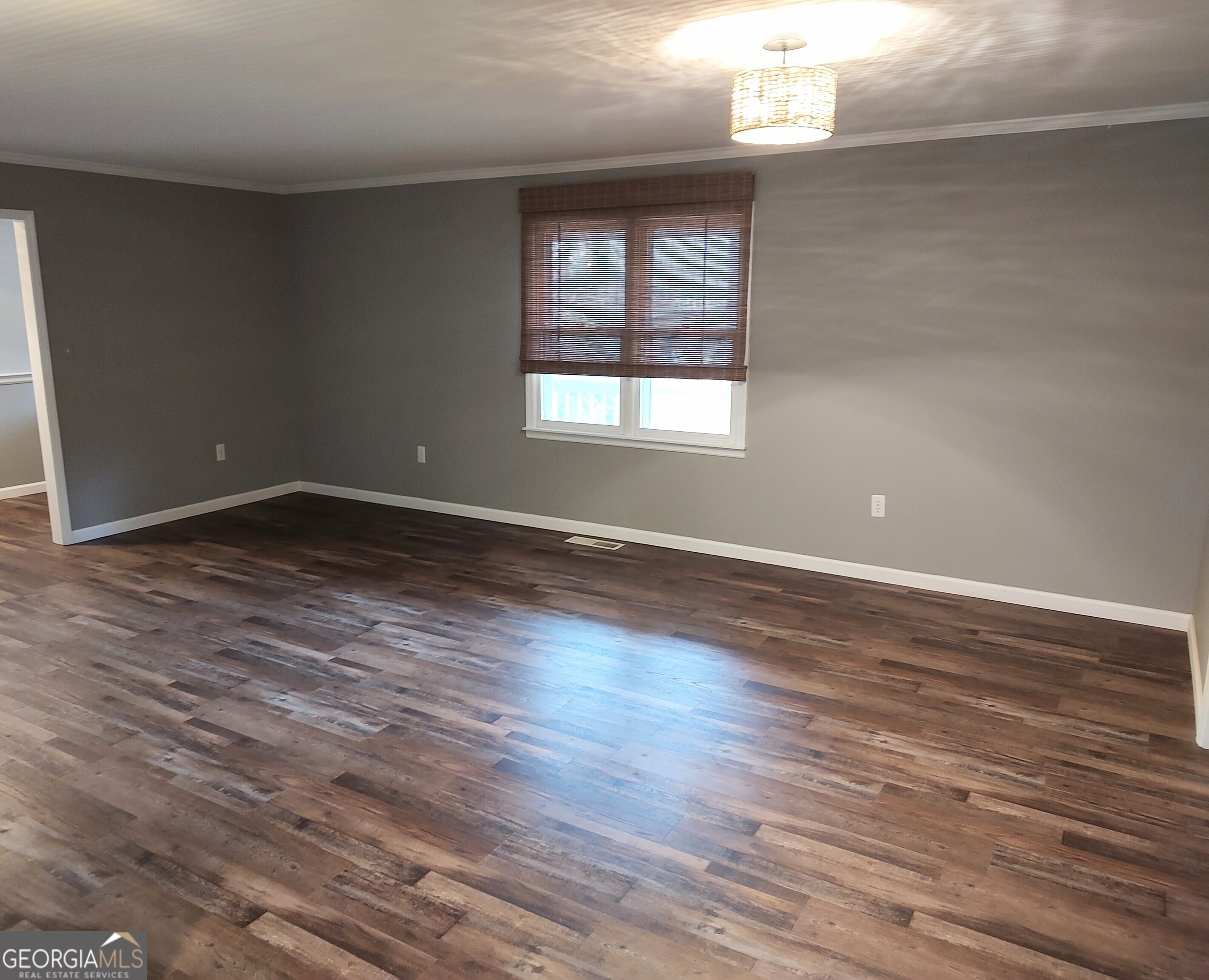 615 Hemlock Drive Thomson, GA 30824 - Photo 4 of 32 an empty room with wooden floor and windows