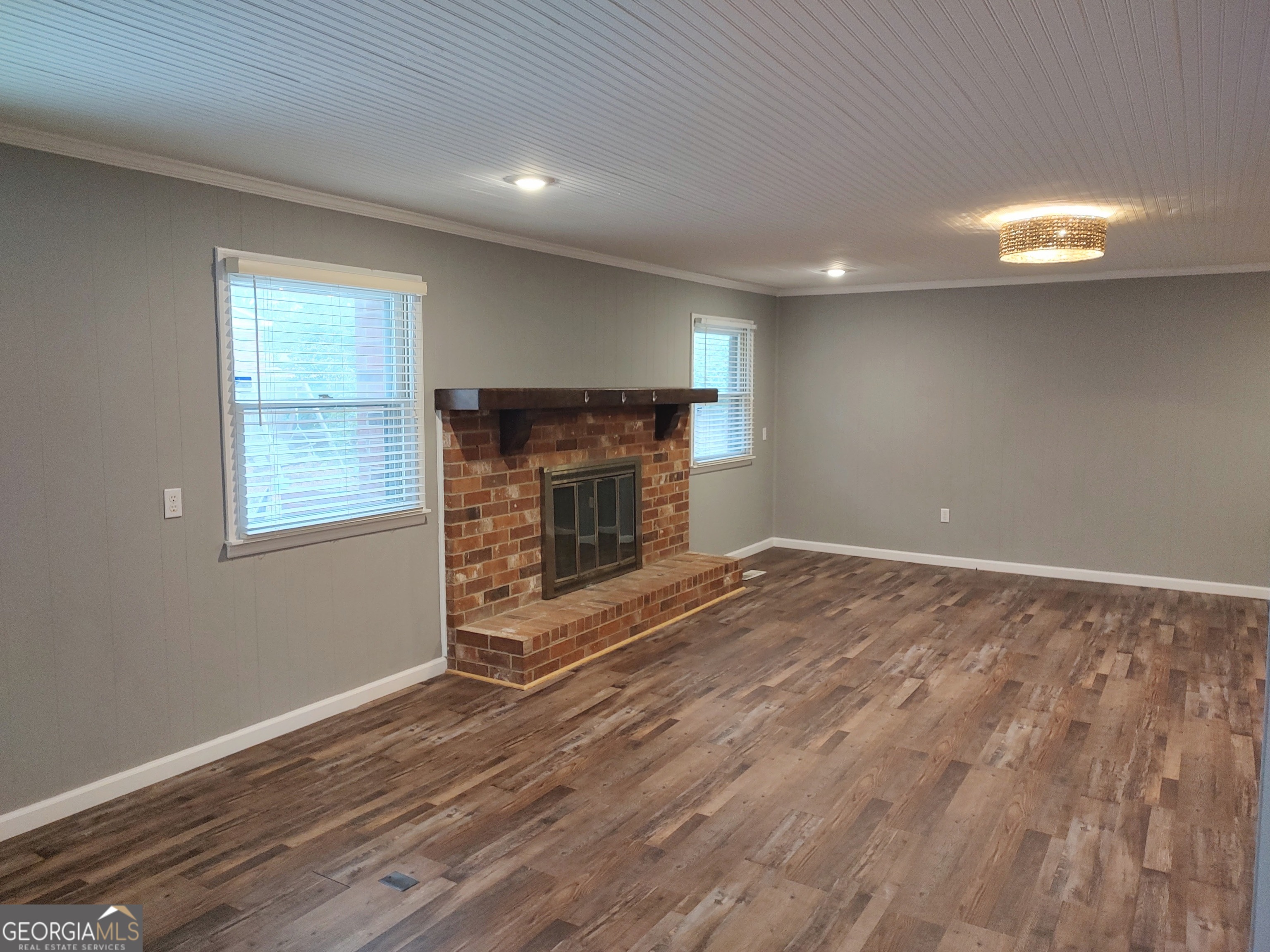615 Hemlock Drive Thomson, GA 30824 - Photo 7 of 32 an empty room with wooden floor fireplace and windows