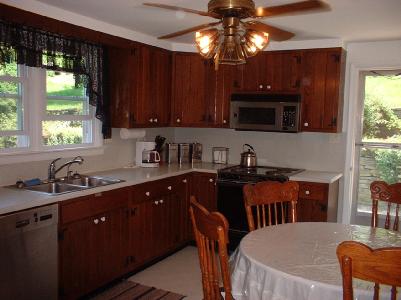 7525 Hahn Road Bangor, PA 18013 - Photo 8 of 10 a kitchen with stainless steel appliances granite countertop a sink dishwasher a stove a refrigerator a dining table and chairs with wooden floor