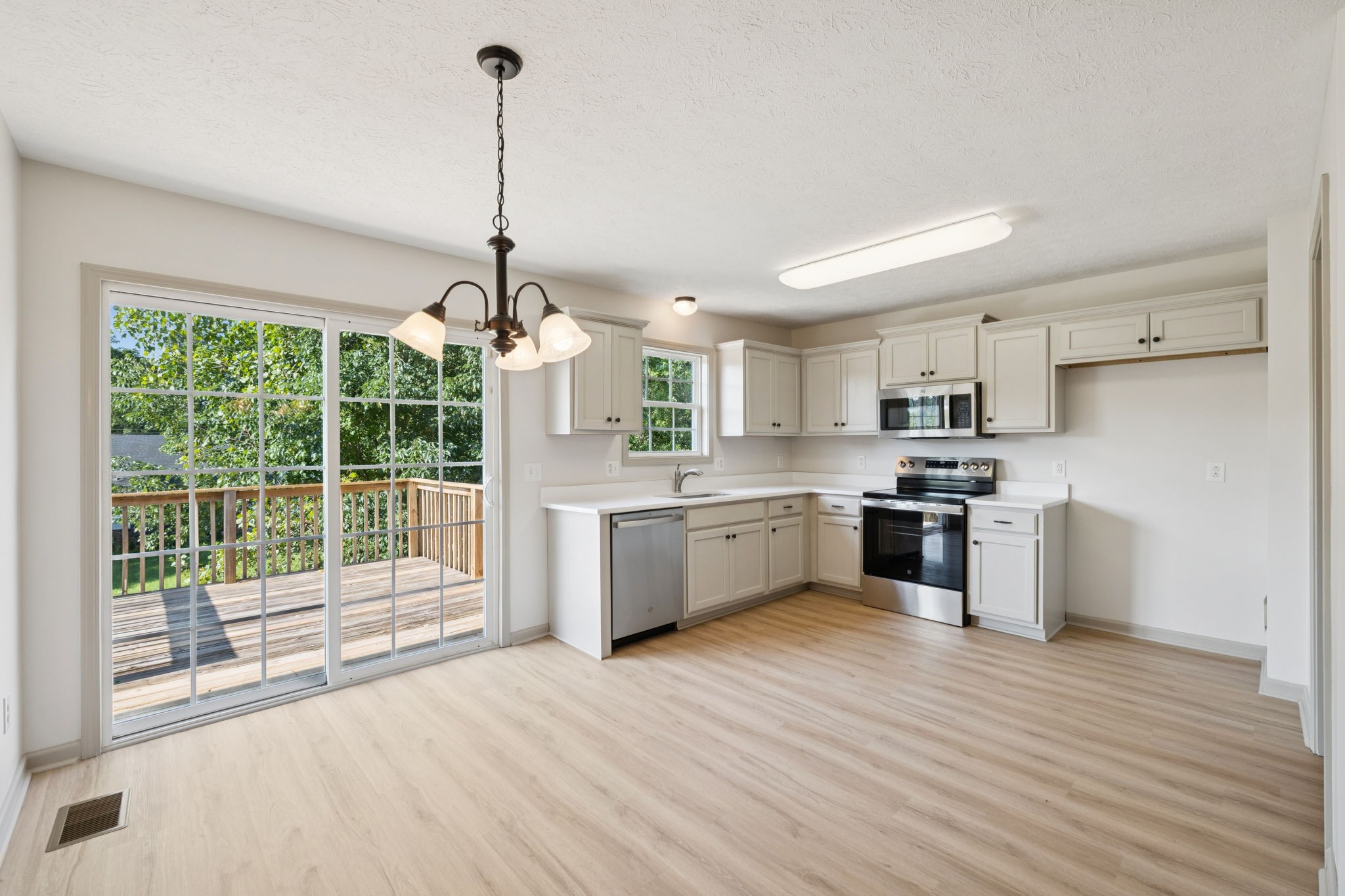 607 Berry Circle Springfield, TN 37172 - Photo 18 of 27 a kitchen with stainless steel appliances granite countertop a stove a sink dishwasher a refrigerator and white cabinets with wooden floor