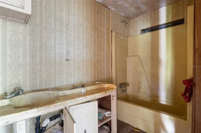 a bathroom with a granite countertop sink and a mirror next to a window