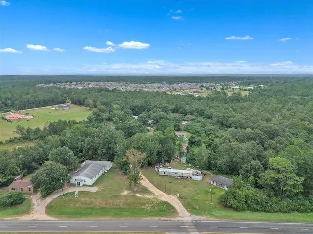 an aerial view of residential houses with outdoor space and trees