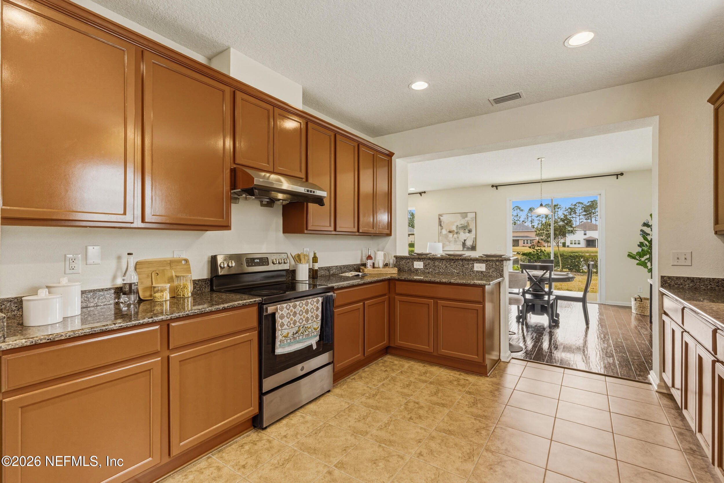 270 Carnation Street St. Johns, FL 32259 - Photo 14 of 56 a kitchen with stainless steel appliances granite countertop wooden cabinets a stove top oven a sink and dishwasher