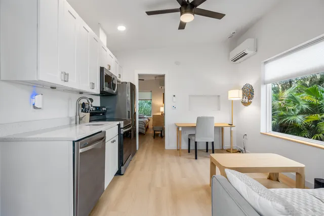 a kitchen with a table chairs microwave and cabinets