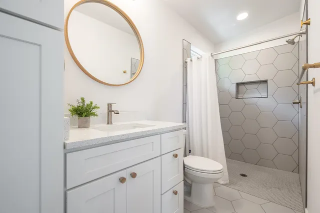 a bathroom with a sink a toilet and shower