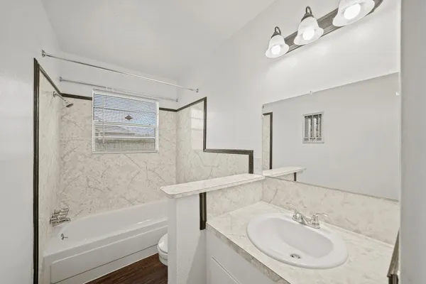 a bathroom with a sink a toilet and shower