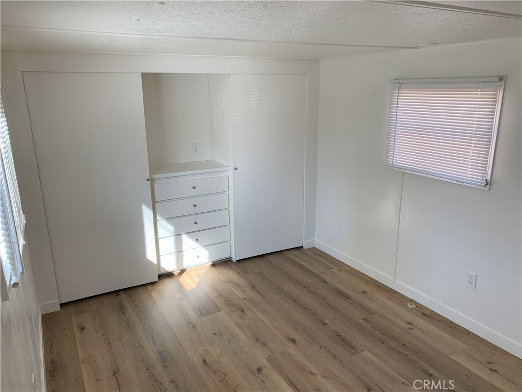 5925 Riverside Drive, Unit 12 Chino, CA 91710 - Photo 12 of 16 an empty room with wooden floor & cabinet