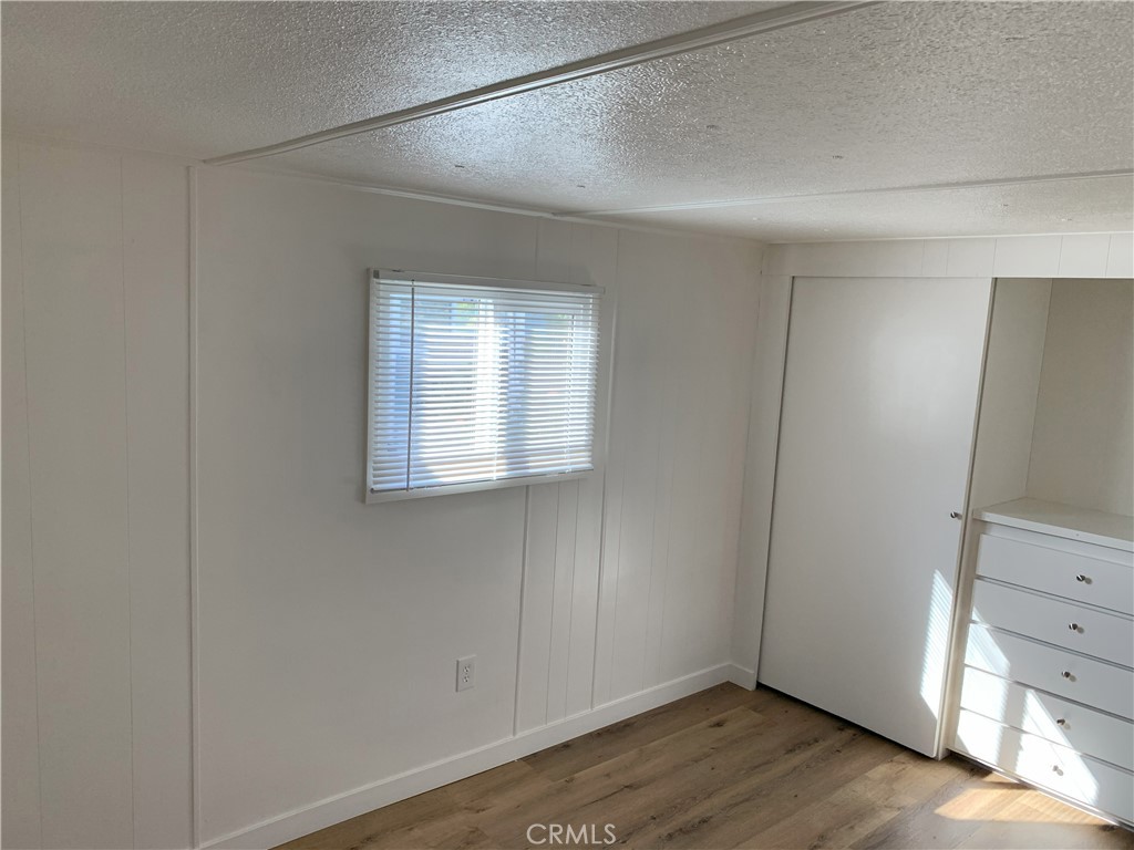 5925 Riverside Drive, Unit 12 Chino, CA 91710 - Photo 14 of 16 a view of an empty room with closet and wooden floor
