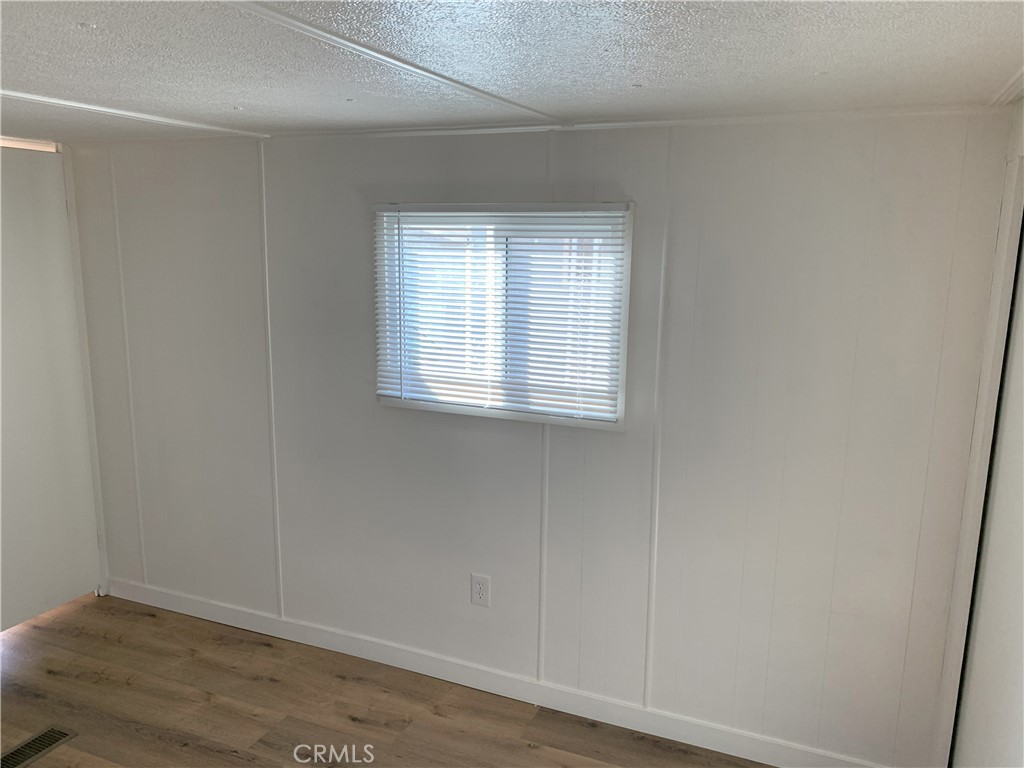 5925 Riverside Drive, Unit 12 Chino, CA 91710 - Photo 15 of 16 an empty room with wooden floor and windows
