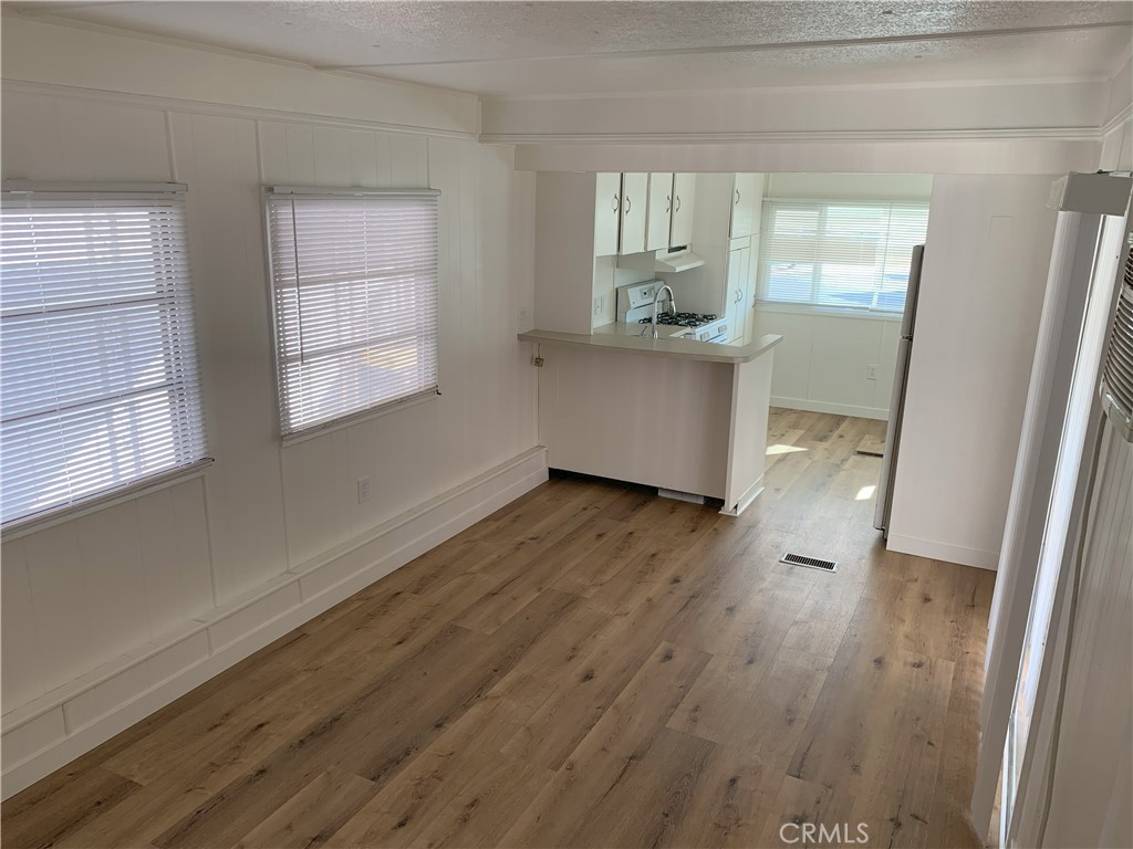 5925 Riverside Drive, Unit 12 Chino, CA 91710 - Photo 5 of 16 an empty room with wooden floor and windows