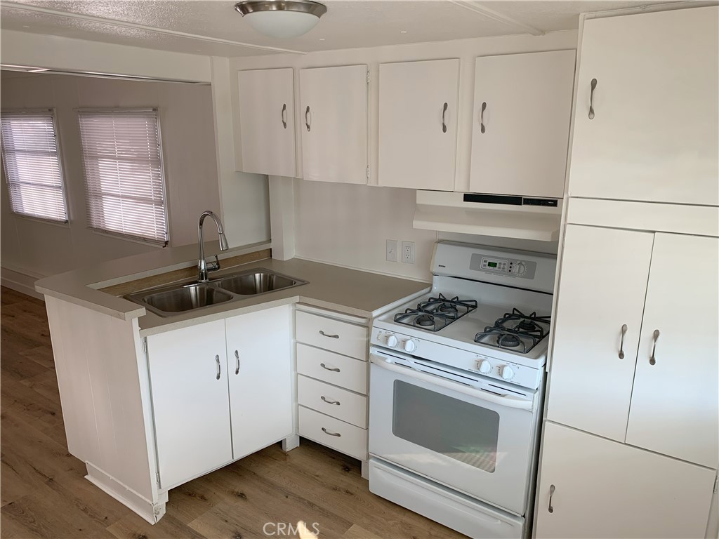 5925 Riverside Drive, Unit 12 Chino, CA 91710 - Photo 7 of 16 a kitchen with white cabinets and white appliances