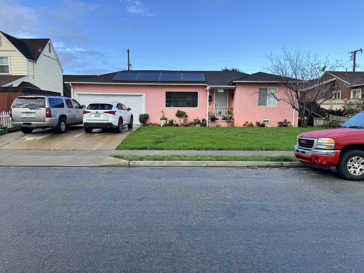 a front view of a house with a garden and parking space
