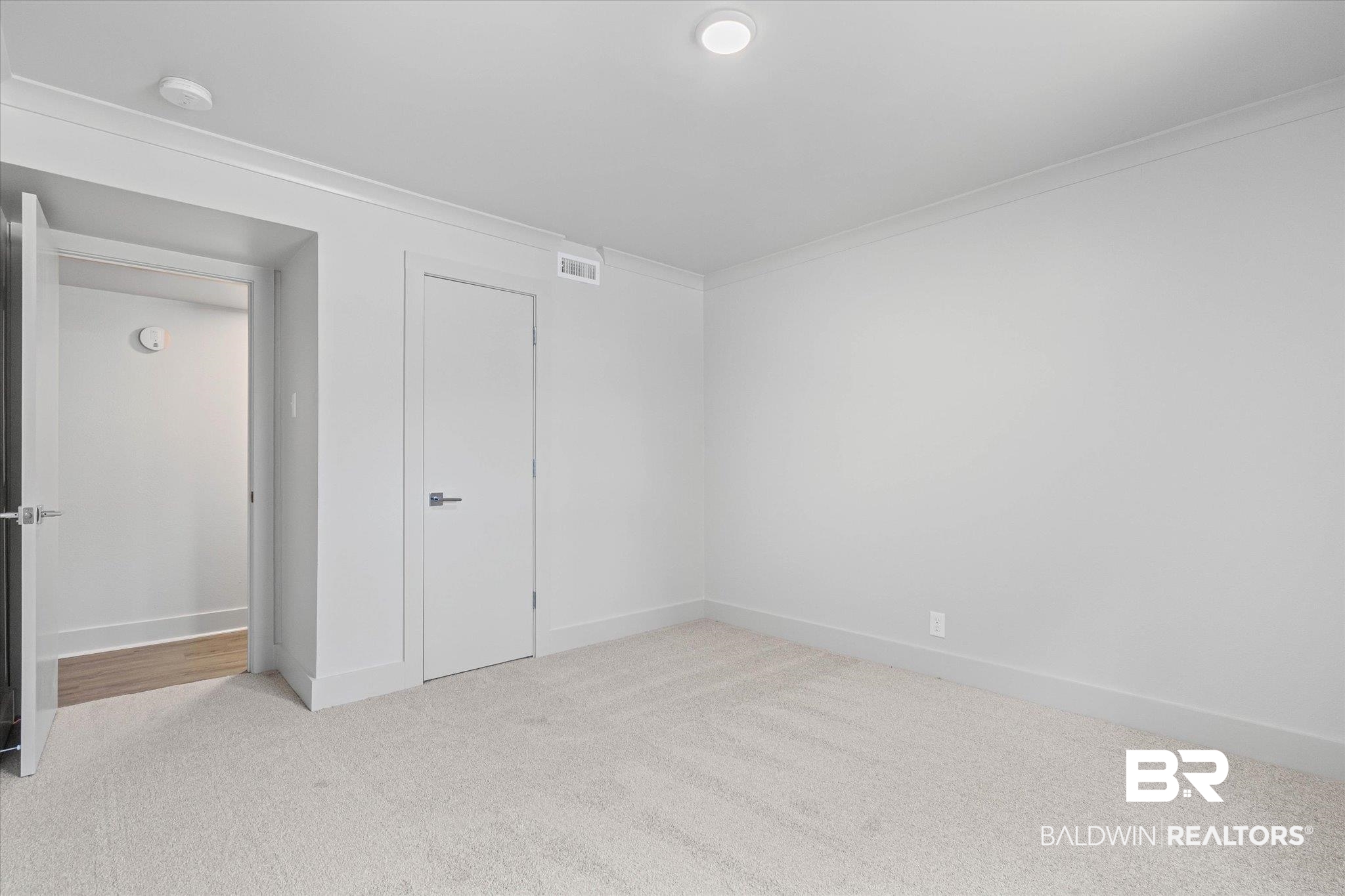3655 Old Shell Road, Unit 712 Mobile, AL 36608 - Photo 12 of 19 Unfurnished bedroom featuring light carpet, a closet, and crown molding