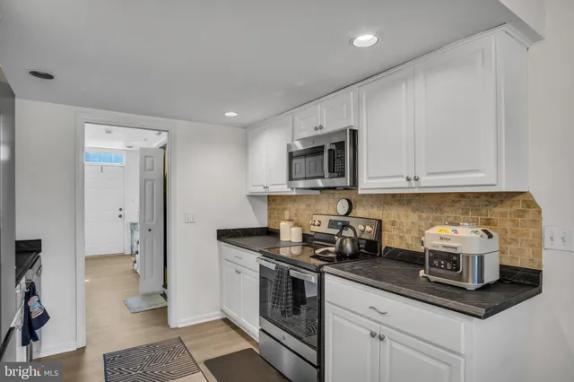 a kitchen with stainless steel appliances granite countertop a sink a stove and a refrigerator