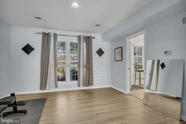 a view of an empty room with glass door and a window
