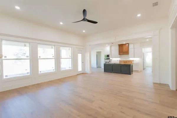 a view of an empty room with a window and wooden floor