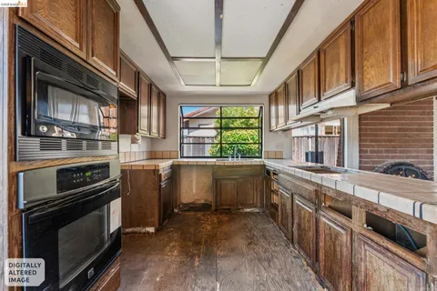 a kitchen with kitchen island granite countertop a stove and a sink