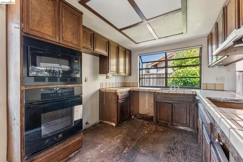 a kitchen with kitchen island granite countertop a stove and a sink