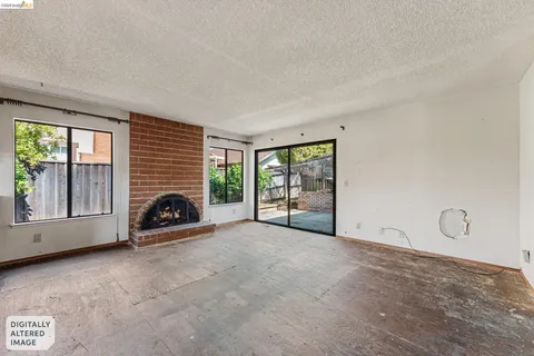 a view of an empty room with a fireplace and a window