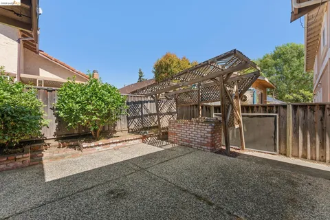 a view of a blue house with iron fence