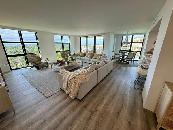 a living room with furniture wooden floor and a large window