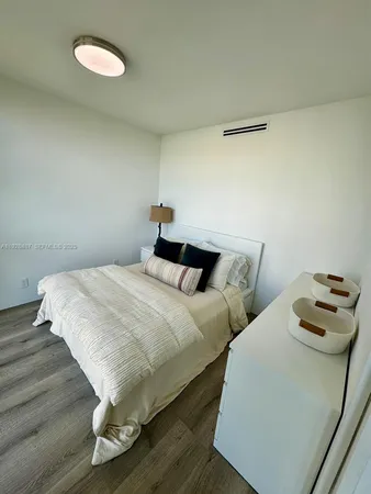 a bedroom with two beds and a wooden floor