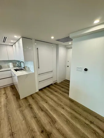 a view of a kitchen with a refrigerator and a sink