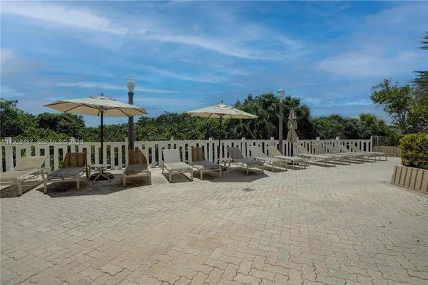 a view of a patio with a table and chairs under an umbrella