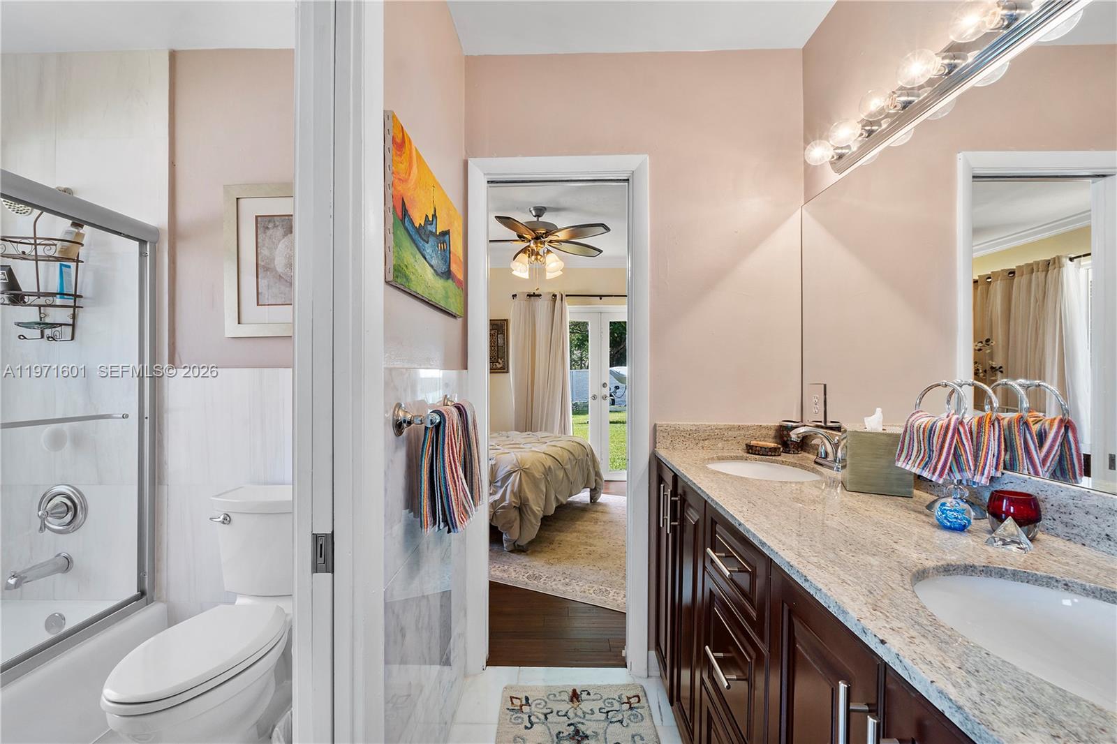 17640 Old Cutler Road Palmetto Bay, FL 33157 - Photo 27 of 56 a en suite bathroom with a granite countertop sink and a mirror