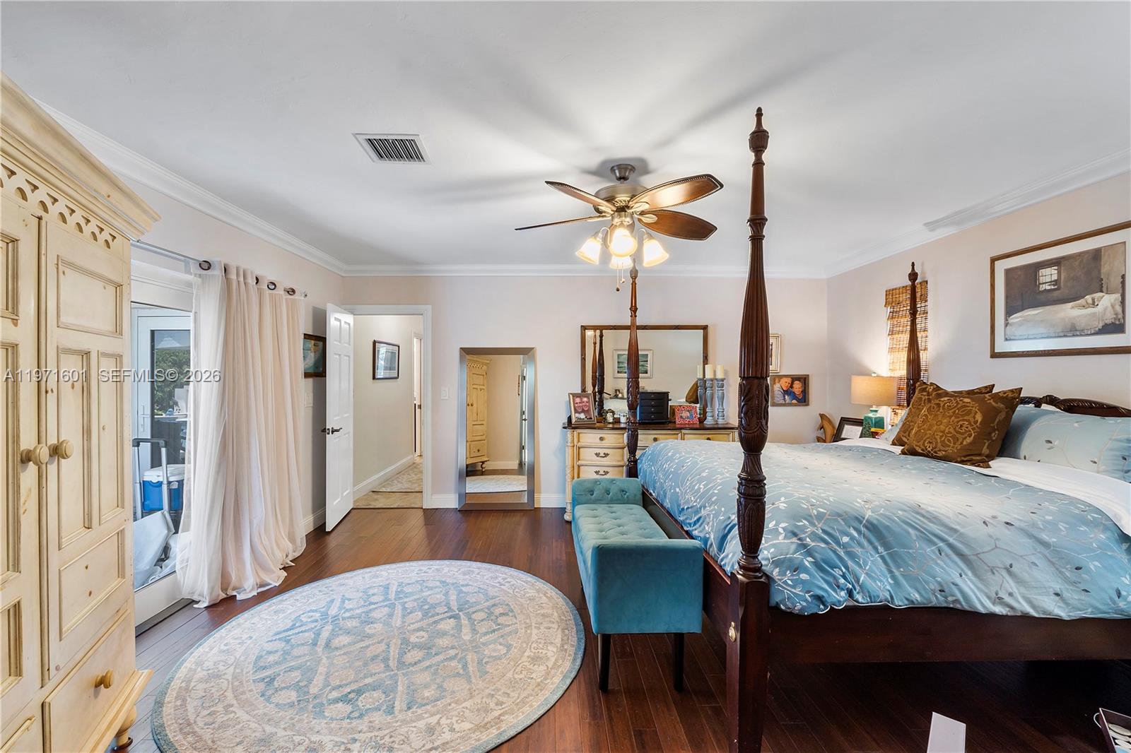 17640 Old Cutler Road Palmetto Bay, FL 33157 - Photo 30 of 56 a bedroom with a bed a chandelier and a mirror