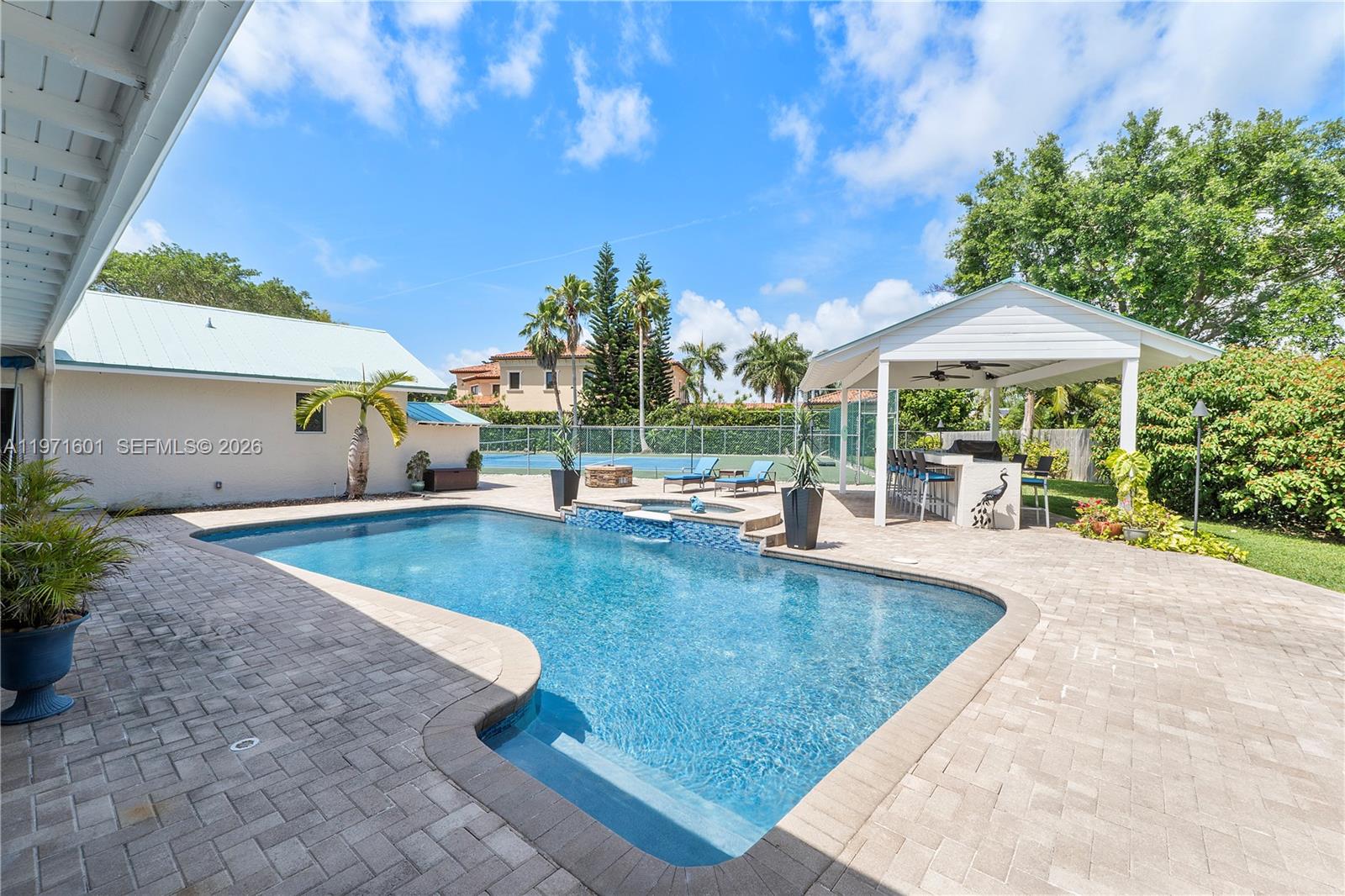 17640 Old Cutler Road Palmetto Bay, FL 33157 - Photo 47 of 56 a view of a patio with a table and chairs under an umbrella