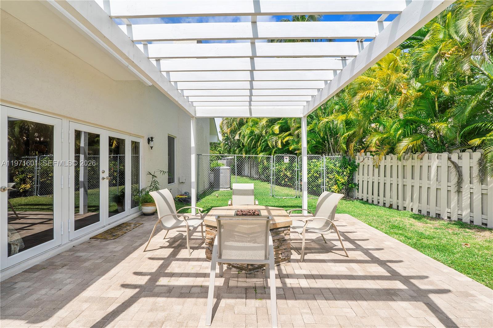 17640 Old Cutler Road Palmetto Bay, FL 33157 - Photo 52 of 56 a view of a patio with a dining table and chairs with wooden floor and fence
