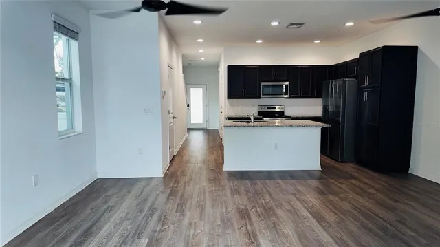 a kitchen with stainless steel appliances a refrigerator and a stove top oven
