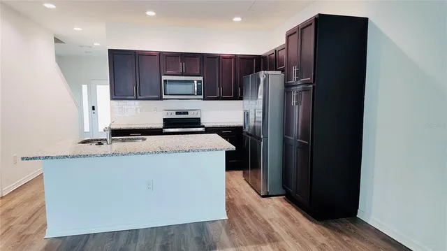 a kitchen with stainless steel appliances granite countertop a refrigerator and a stove top oven