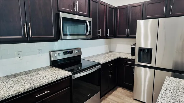 a kitchen with granite countertop stainless steel appliances and wooden cabinets