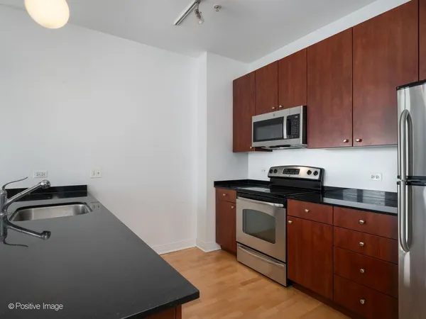 a kitchen with sink a microwave and cabinets