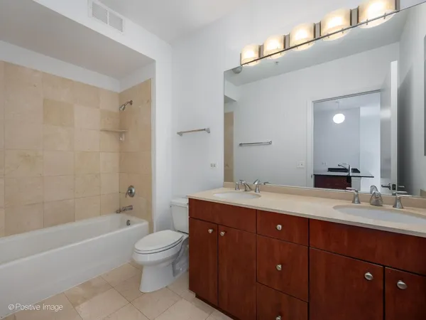 a spacious bathroom with a granite countertop sink toilet mirror and bathtub
