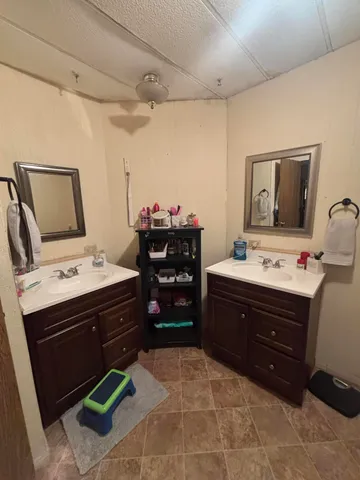 a bathroom with a granite countertop sink a toilet a mirror and shower