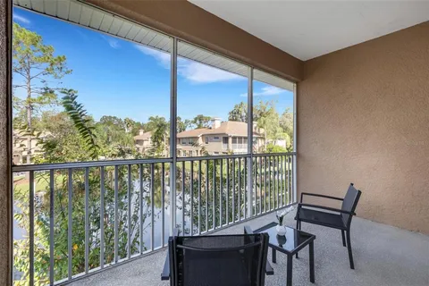 an empty room with a chandelier fan and windows