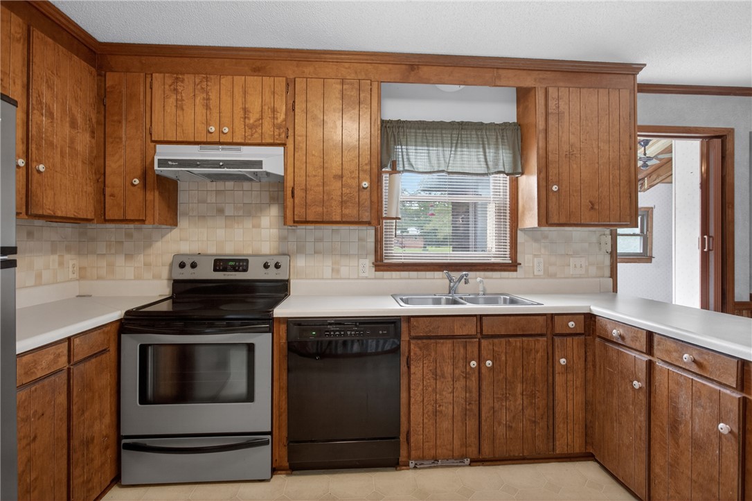 112 Holliday Lane Pendleton, SC 29670 - Photo 12 of 42 A well-appointed kitchen features ample wood cabinetry, a stainless steel range, and a dual basin sink beneath a window.