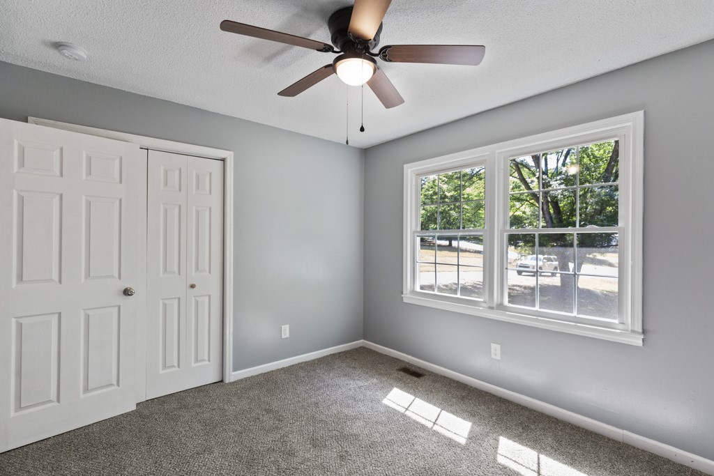 104 Doyle Drive Seneca, SC 29678 - Photo 8 of 19 This bright room features a ceiling fan, plush carpeting, and sunlit windows.