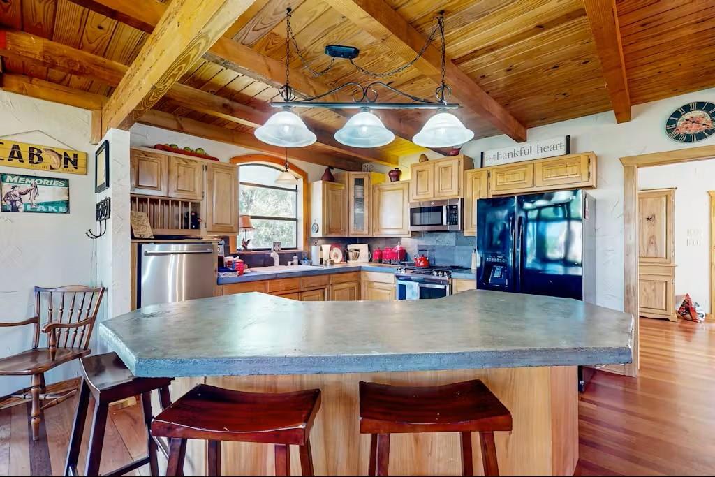 120 Live Oak Road Whitney, TX 76692 - Photo 7 of 21 a kitchen with stainless steel appliances granite countertop a table chairs and a refrigerator