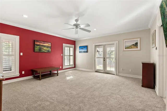 a view of an empty room with window and a ceiling fan