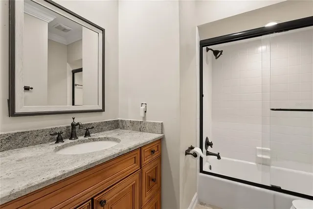 a bathroom with a granite countertop sink mirror vanity and shower