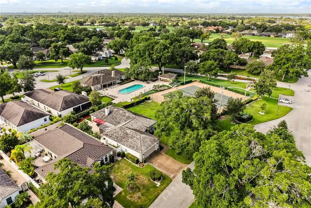 an aerial view of residential houses with outdoor space and trees