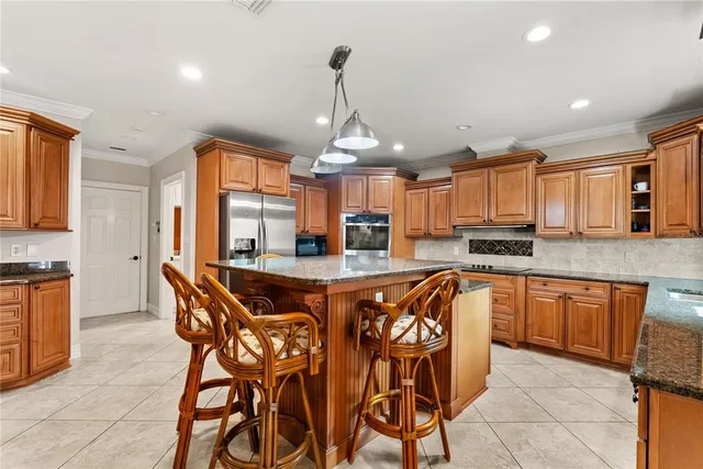 a dining area with stainless steel appliances granite countertop a kitchen island a stove a table and chairs