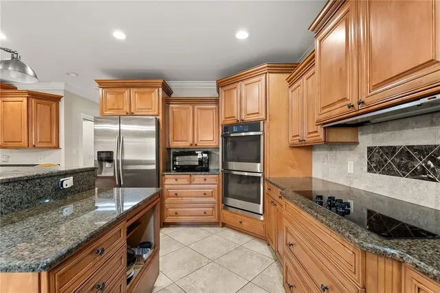 a kitchen with stainless steel appliances granite countertop a sink a stove and a refrigerator