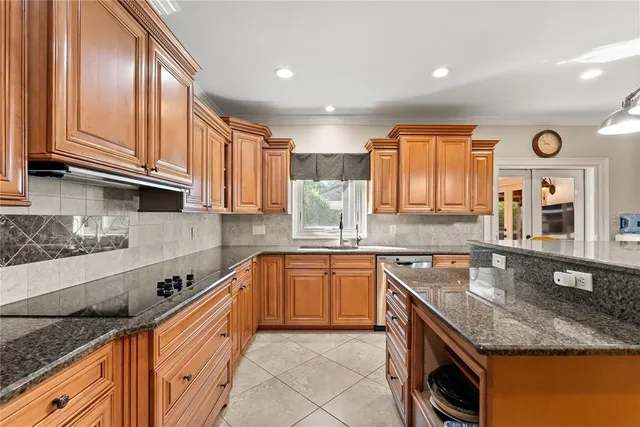 a kitchen with stainless steel appliances granite countertop a sink stove and cabinets